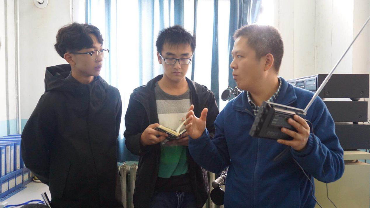 郑州人民广播电台技术人员朱祖来(右)与tyc234cc太阳成集团广播站负责人在调试信号